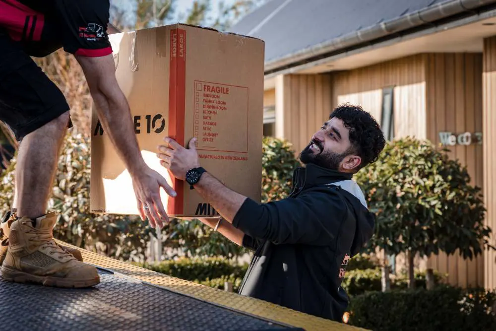 Movers loading a single item safely into the truck