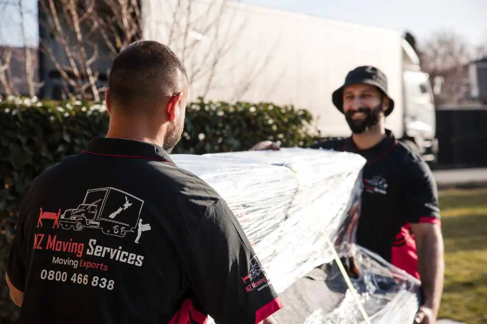 Team of piano movers safely transporting a piano to the truck