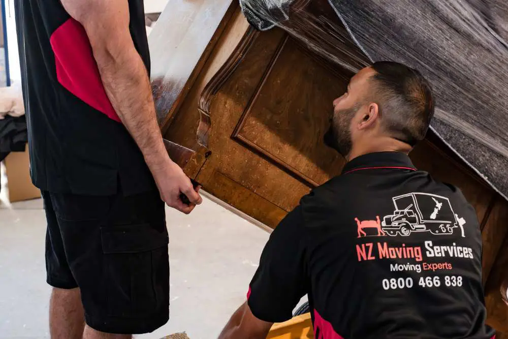 Piano movers carefully packing and loading a piano for transport